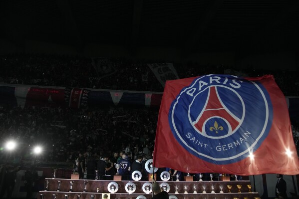 Cờ Paris Saint-Germain được vẫy khi các cầu thủ ăn mừng chức vô địch French League One của PSG sau trận đấu bóng đá French League One giữa Paris Saint-Germain và Toulouse tại sân vận động Parc des Princes ở Paris, Chủ nhật, ngày 12 tháng 5 năm 2024. (Ảnh AP / Christopher Ena) )